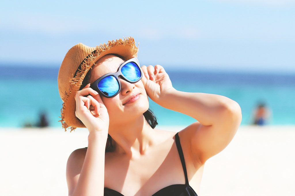 Beautiful woman in Sunglasses sunbathing at beach